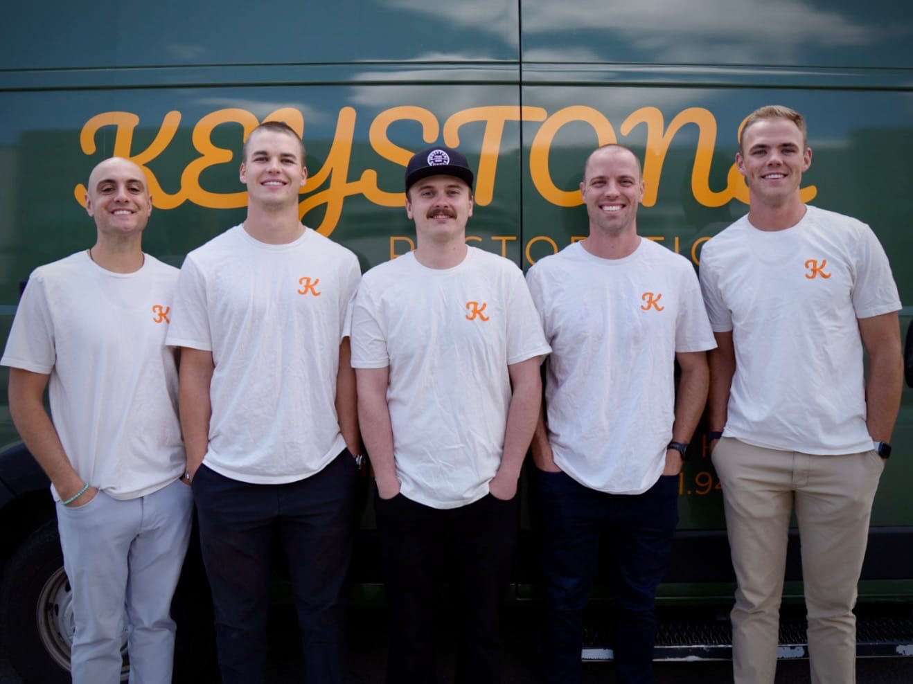 The Keystone Restoration team standing in front of the company van in Bluffdale, Utah